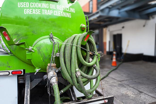 a technician pumping a grease trap in a commercial building in Calabasas, CA